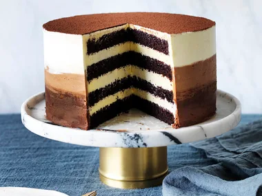 chocolate layer cake with ombre icing and a slice cut out