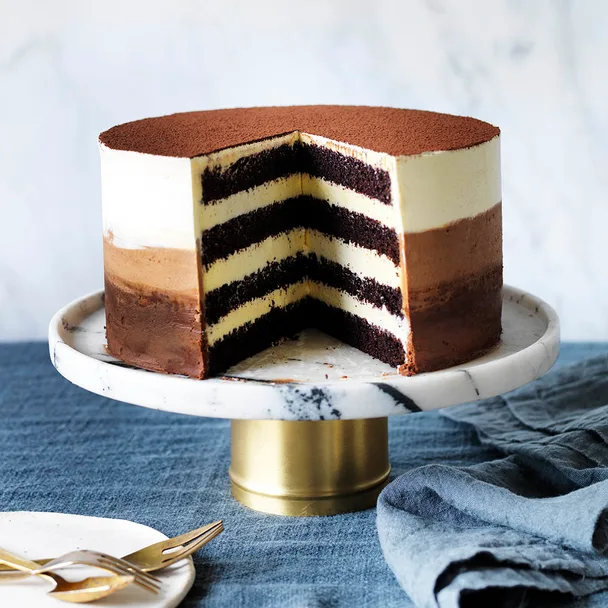 chocolate layer cake with ombre icing and a slice cut out