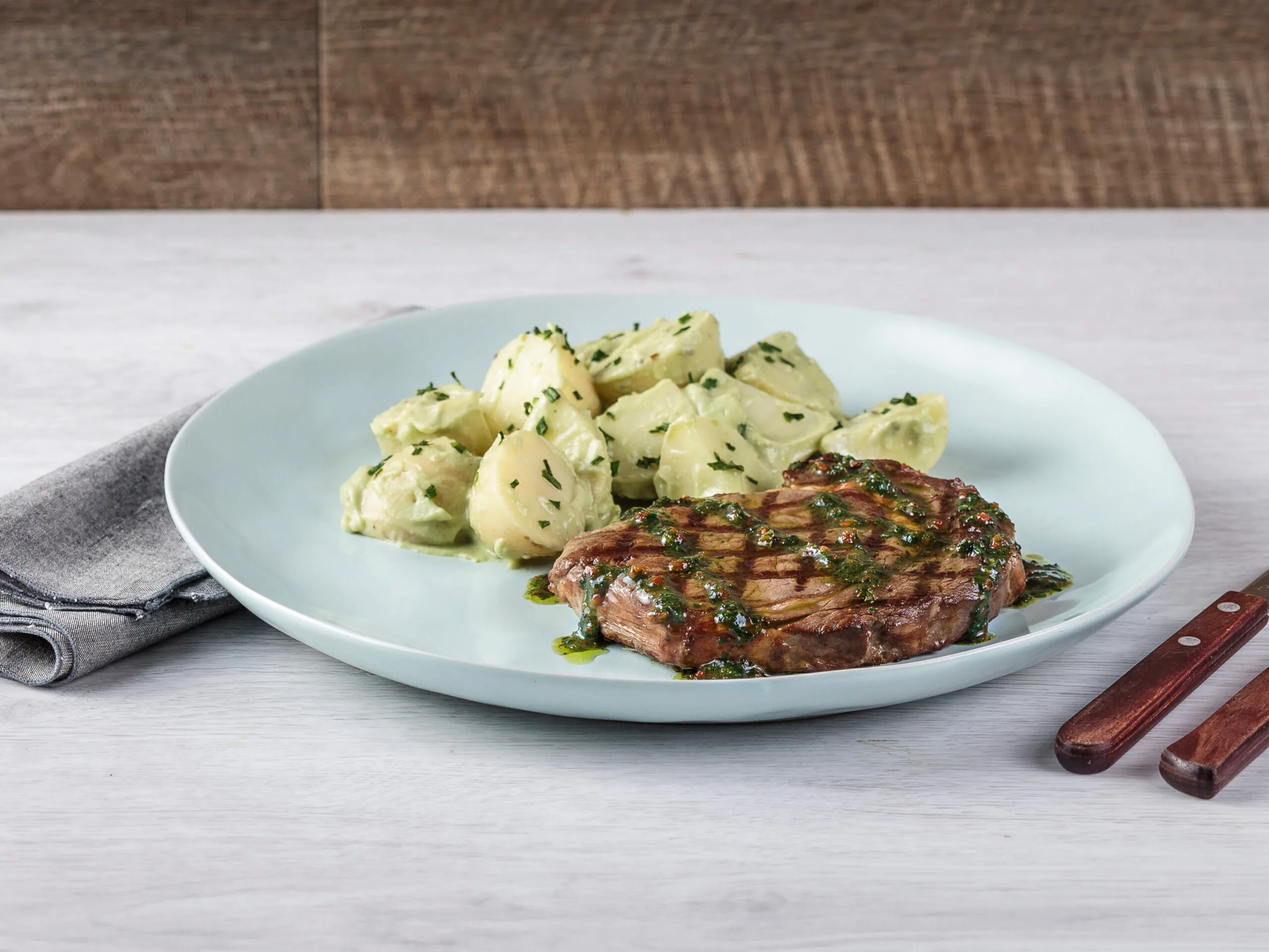Steak with chimichurri drizzle and green potato salad