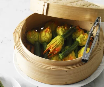 Zucchini flowers stuffed with ricotta and lemon in a steamer basket