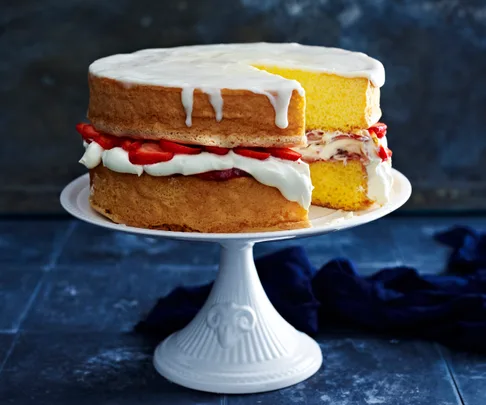 sponge cake on a cake stand with a slice missing