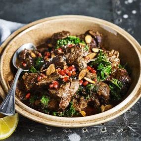 Slow cooker Moroccan lamb shoulder in a bowl with a spoon