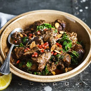 Slow cooker Moroccan lamb shoulder in a bowl with a spoon