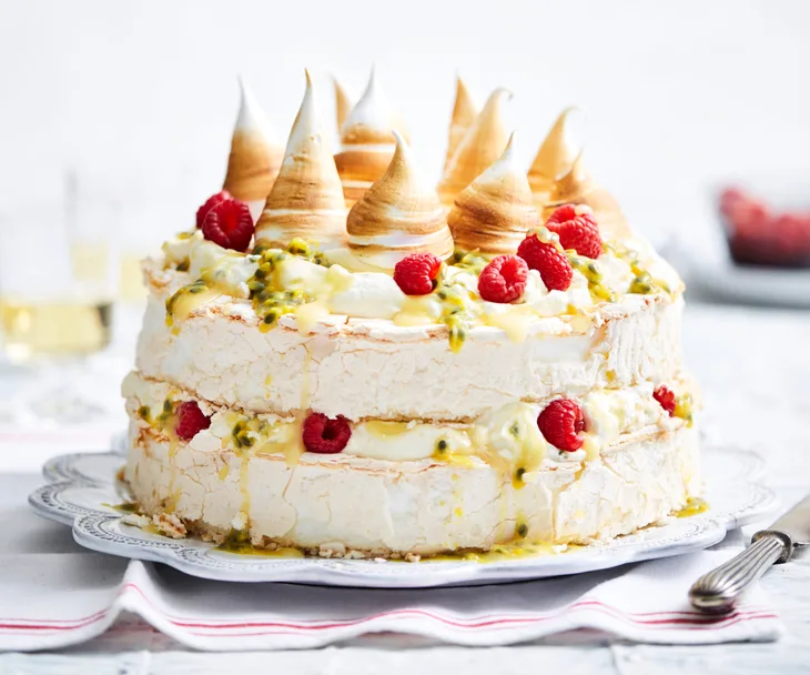 pavlova stack decorated with torched meringue and raspberries