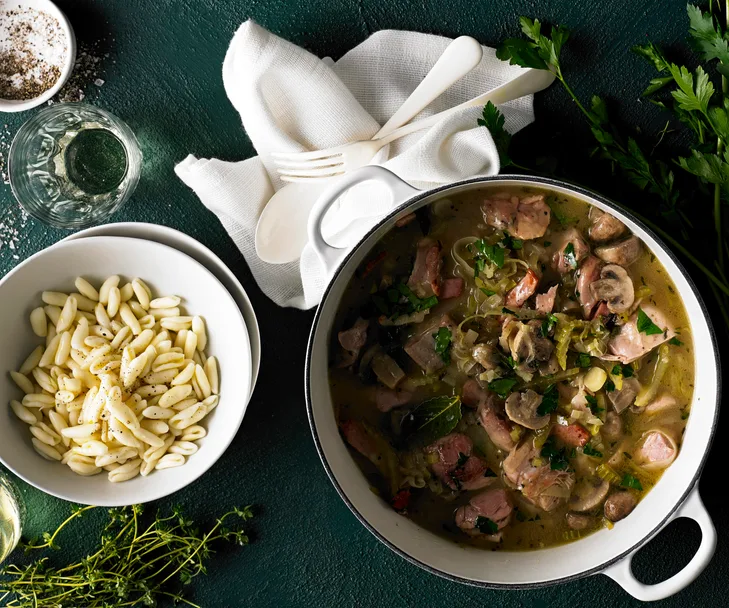 Pot of chicken fricassee stew with a side of pasta