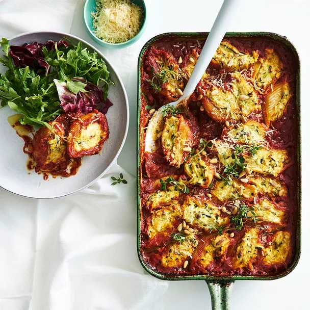 Baking dish filled with stuffed pasta shells and a tomato sauce