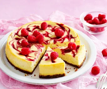 Gluten-free cheesecake with raspberries on a cake plate