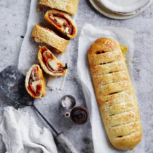 Whole stromboli and sliced stromboli on a bench