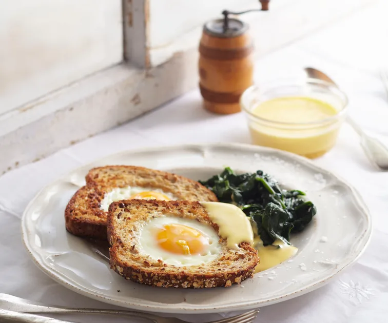 Eggs in bread with wilted spinach and hollandaise sauce
