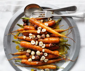 Orange and maple glazed baby carrots with hazelnuts.