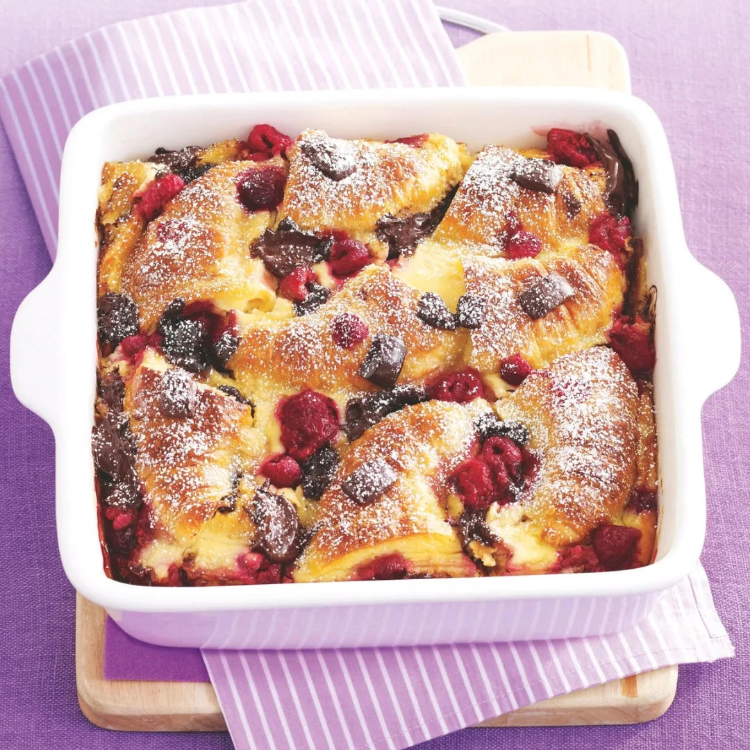 croissant bread and butter pudding with chocolate and raspberries in a square dish