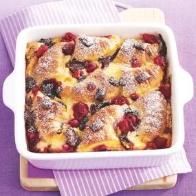 croissant bread and butter pudding with chocolate and raspberries in a square dish