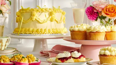 high tea spread with cake, cupcakes, eggs and scones