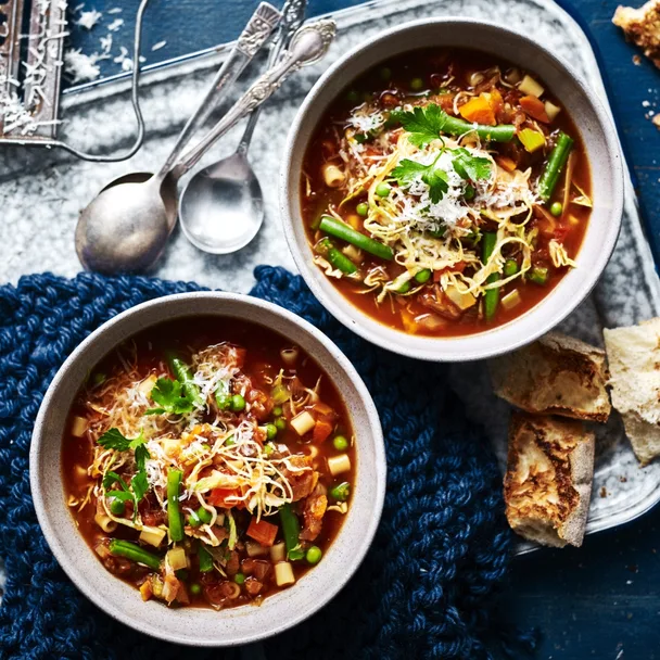 slow cooker vegetable minestrone in two bowls with spoons and bread