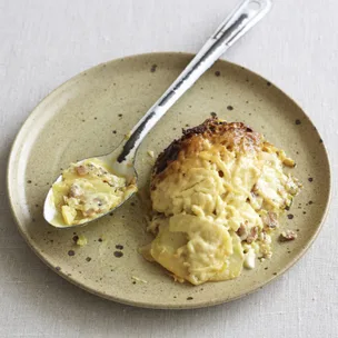 serve of slow cooker potato bake with cream on a plate with a spoon