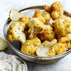 a bowl of cauliflower bites with yoghurt dipping sauce