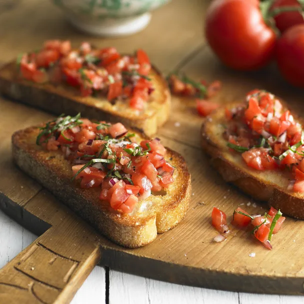 tomato Bruschetta on a wooden chopping board; how to make bruschetta