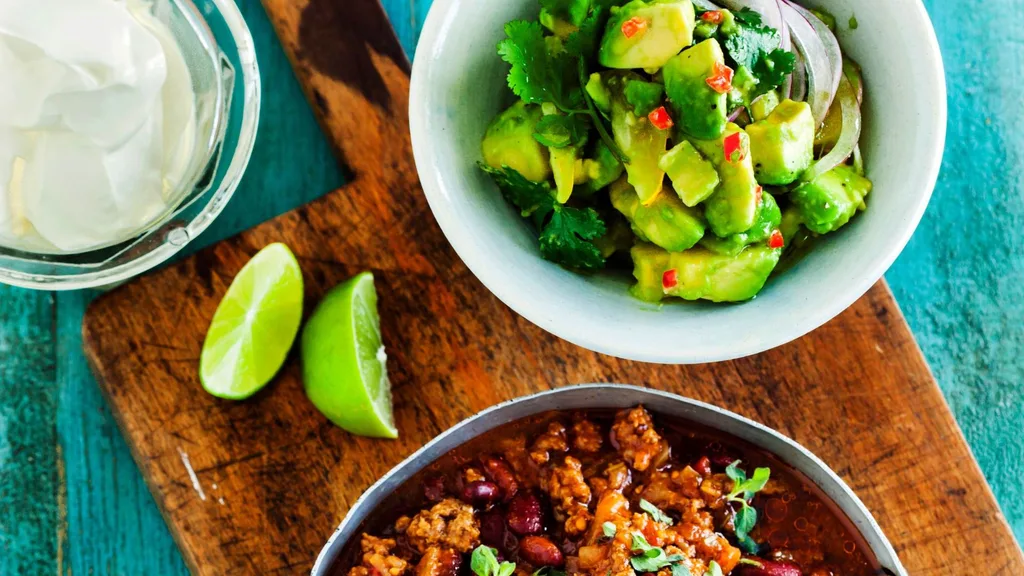Serve chilli con carne with guacamole and sour cream