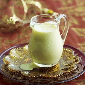vanilla bean egg custard recipe in a glass jug on a patterned plate