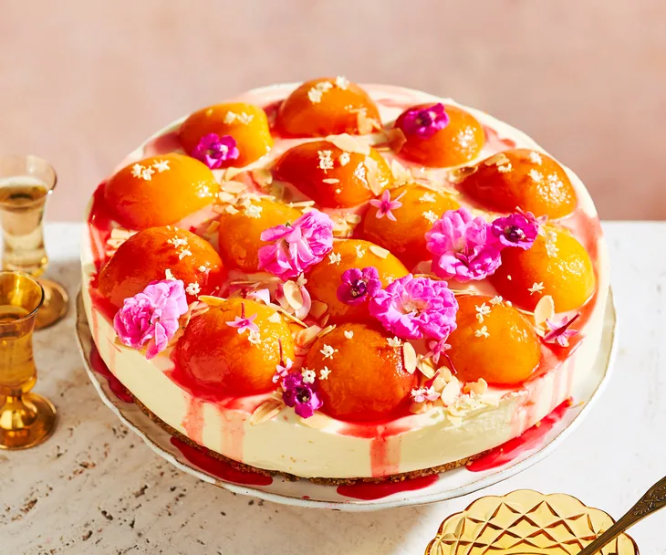 peaches and cream cheesecake on cake stand