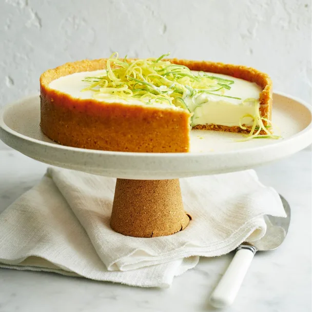 lemon cheesecake on a cake stand with a slice missing