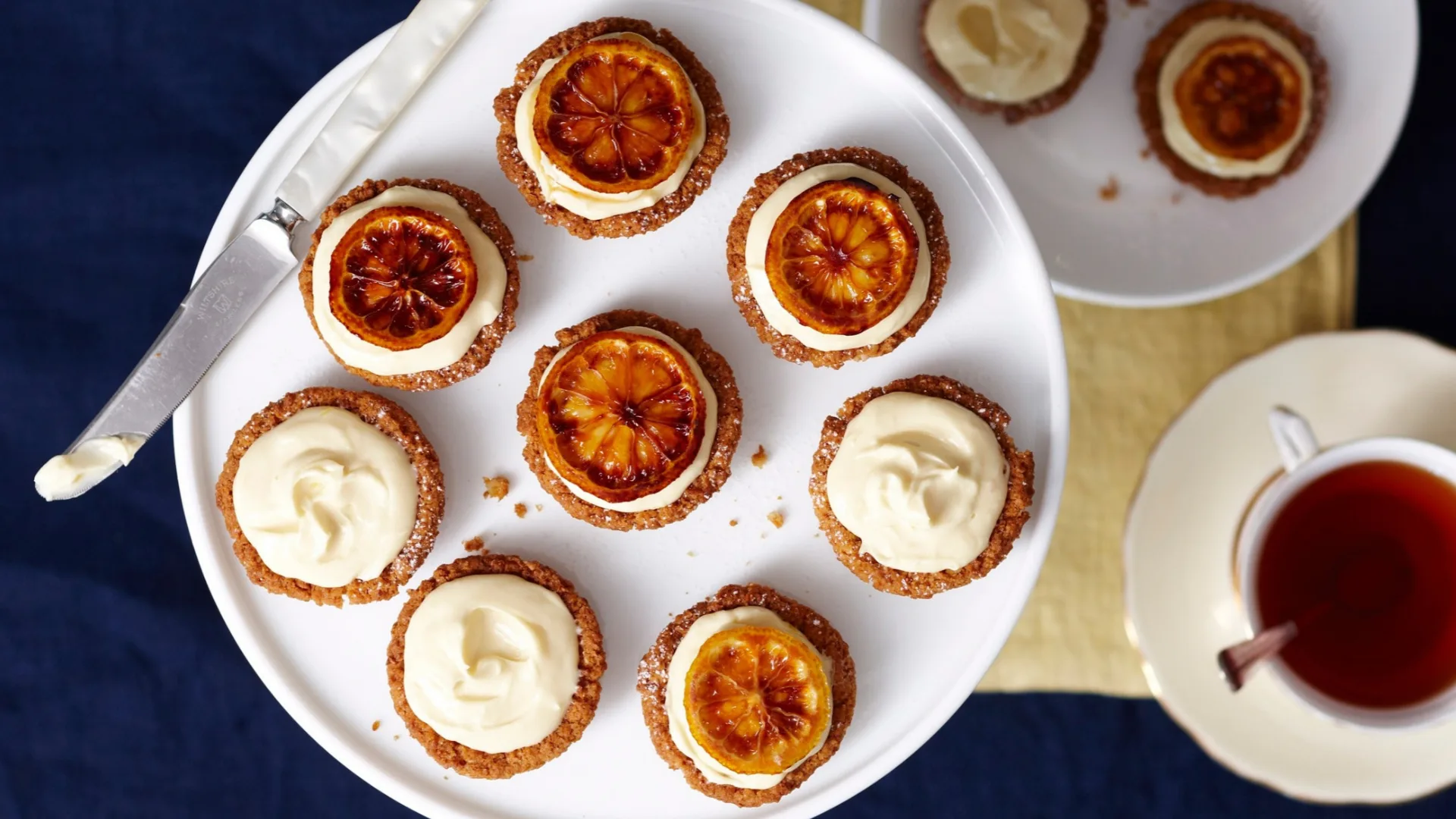 mini lemon cheesecakes on a stand, some topped with lemon slices