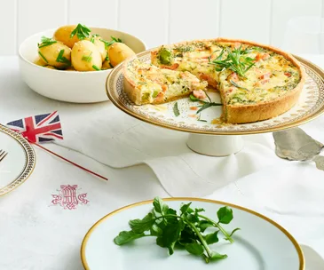 Coronation quiche of salmon, spinach and broadbeans on a cake stand