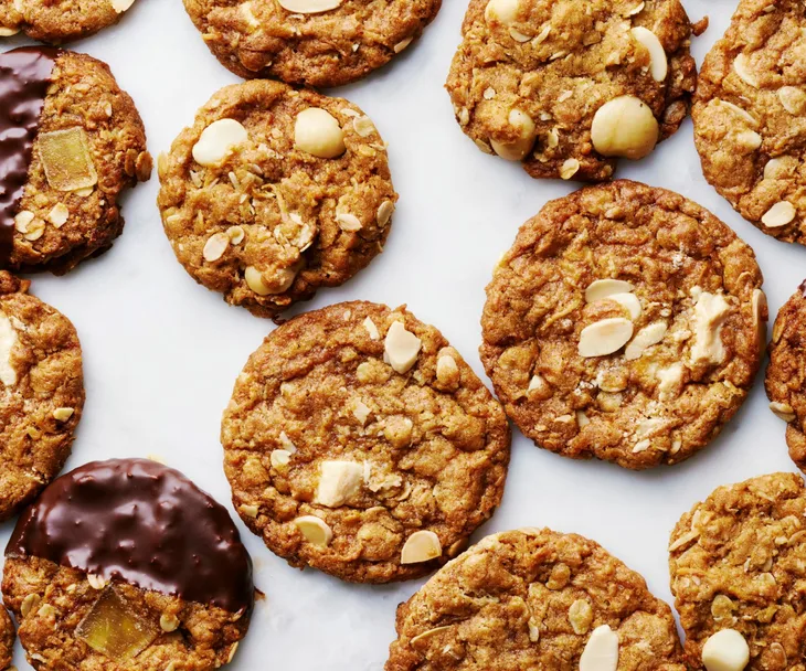 Anzac biscuits on a bench, some covered in chocolate