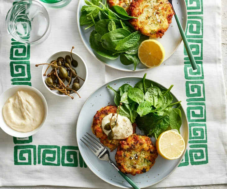 salmon patties on a plate with salad and lemon