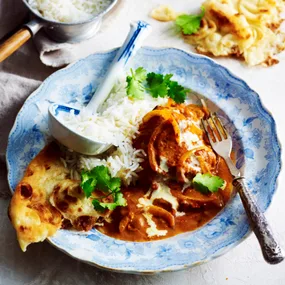 Slow cooker chicken tikka masala with rice and naan in a bowl