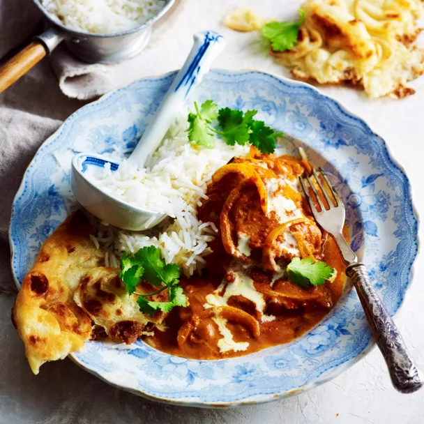 Slow cooker chicken tikka masala with rice and naan in a bowl
