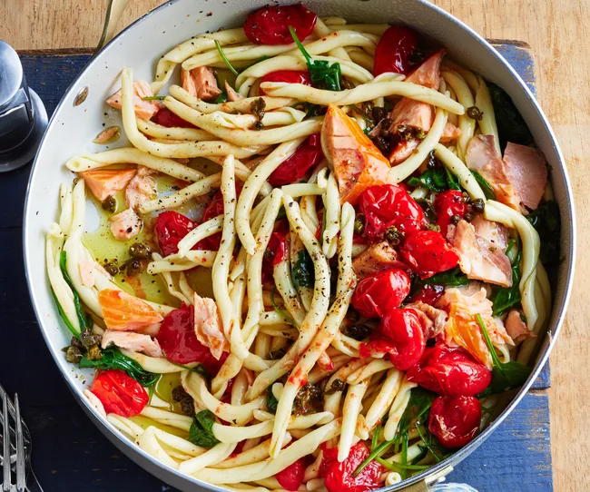 Pan with smoked salmon, pasta, tomatoes and capers.