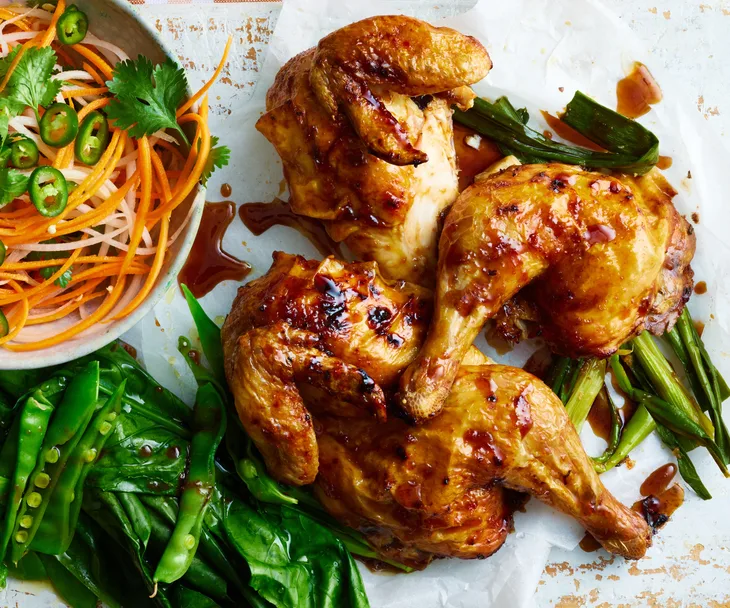 Butterflied soy & ginger chicken next to a bowl of carrot and daikon salad.