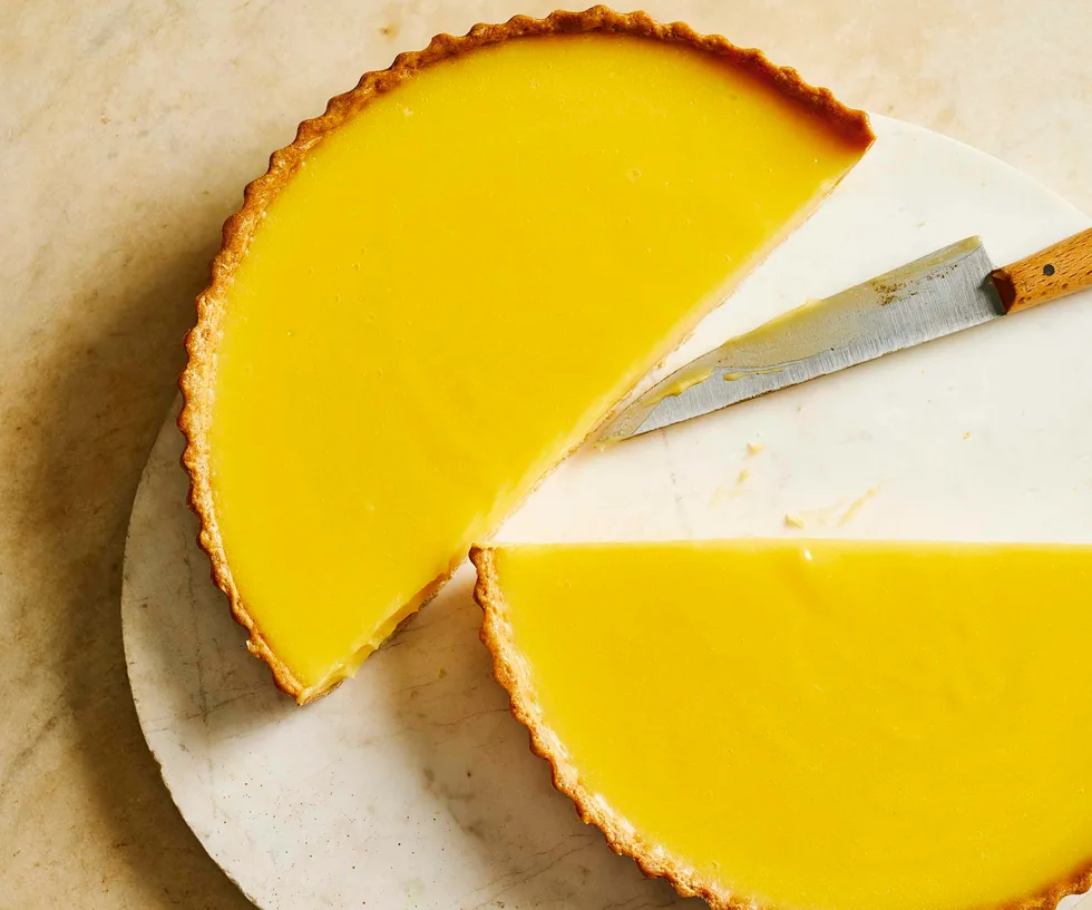 lemon tart on a plate sliced in half