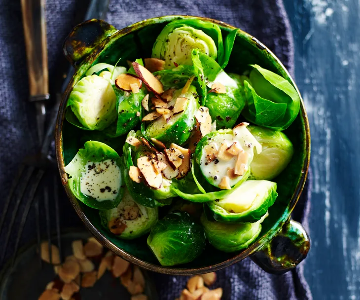 Bowl of creamy Brussels sprouts with toasted almonds.