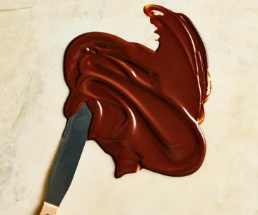 Melted chocolate on a bench with a spatula
