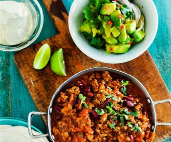 Pot of chilli con carne with a side of diced avocado