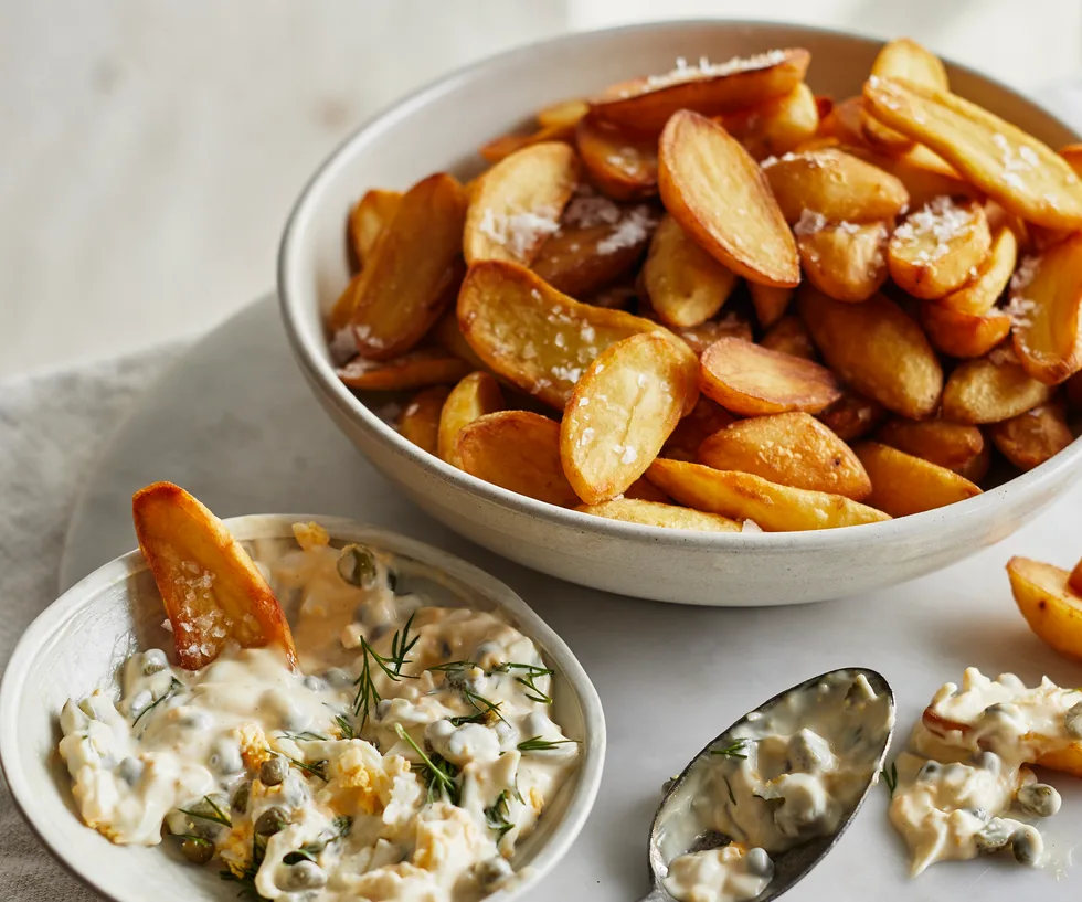 Bowl of crispy kipfler potatoes with a bowl of gribiche sauce