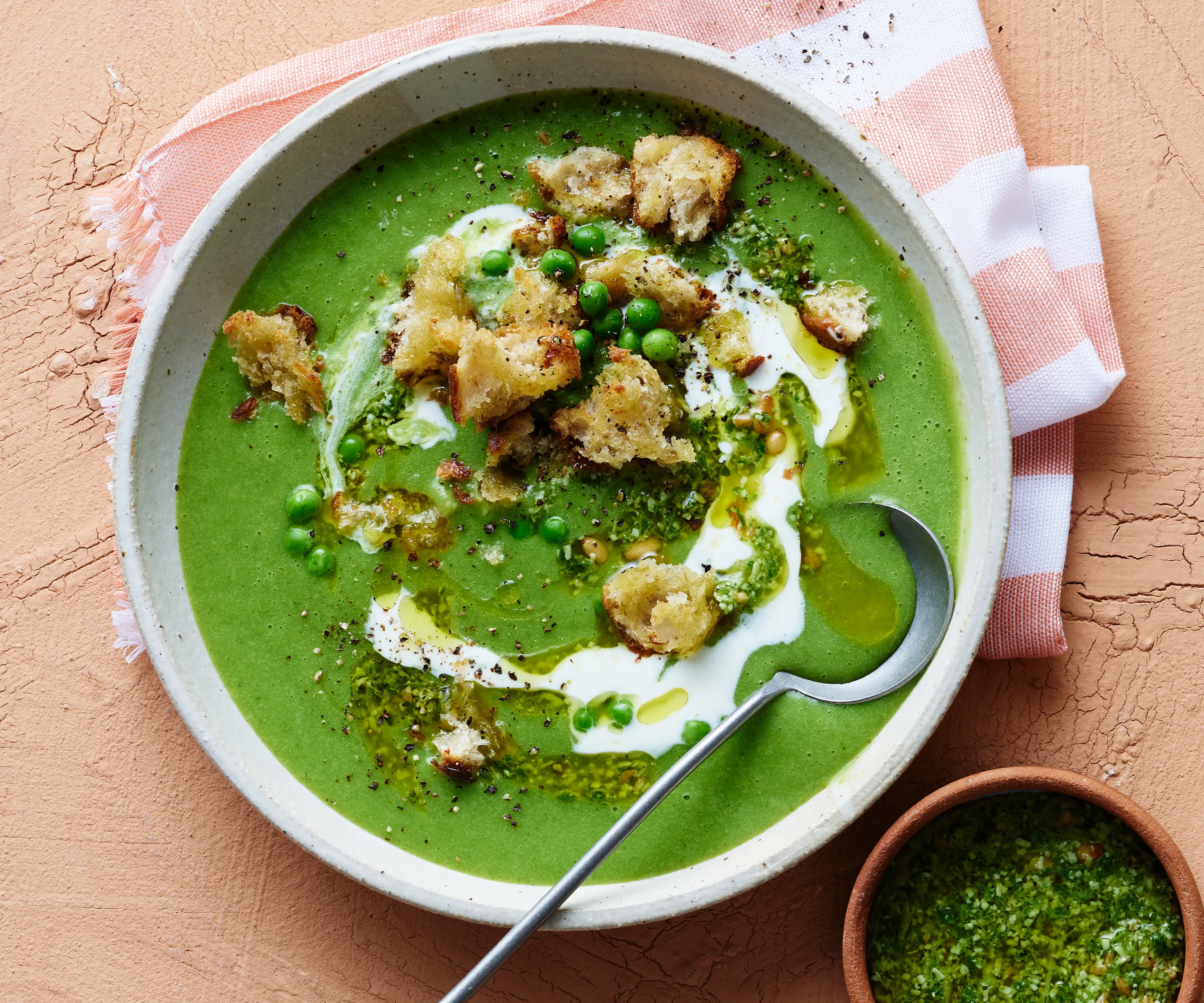 Bowl of pea and pesto soup with croutons