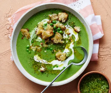 Bowl of pea and pesto soup with croutons