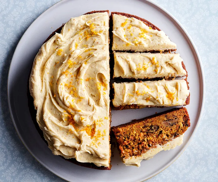 Carrot cake on a plate, half is in slices