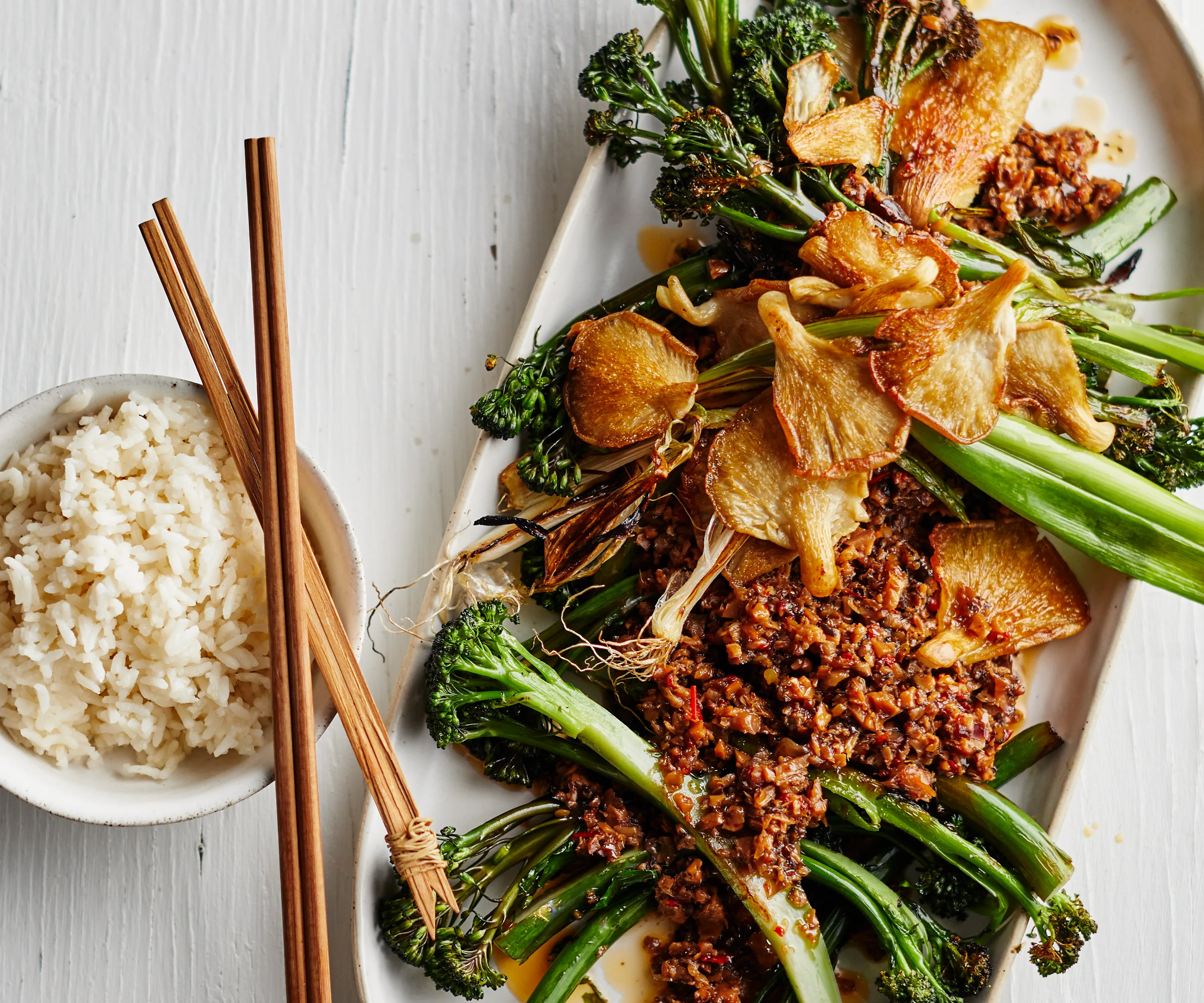 Broccolini topped with shiitake XO sauce served with bowl of rice