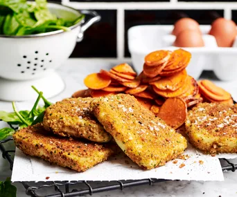 Haloumi schnitzels and sweet potato chips on a metal rack