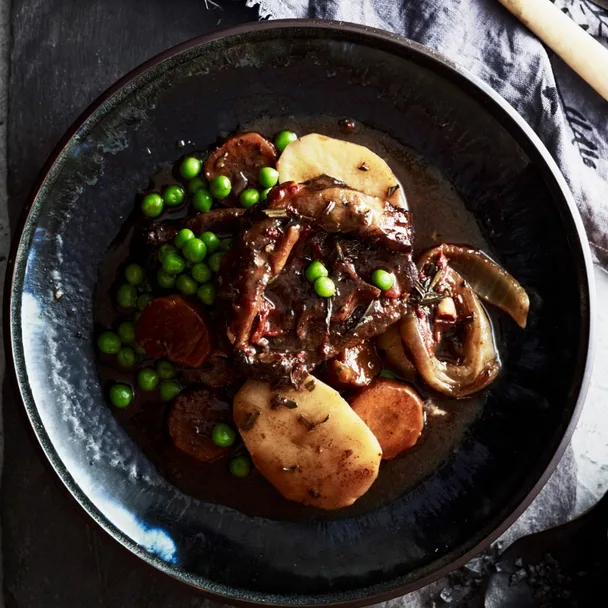lamb stew slow cooker in a bowl with potato, carrot and peas