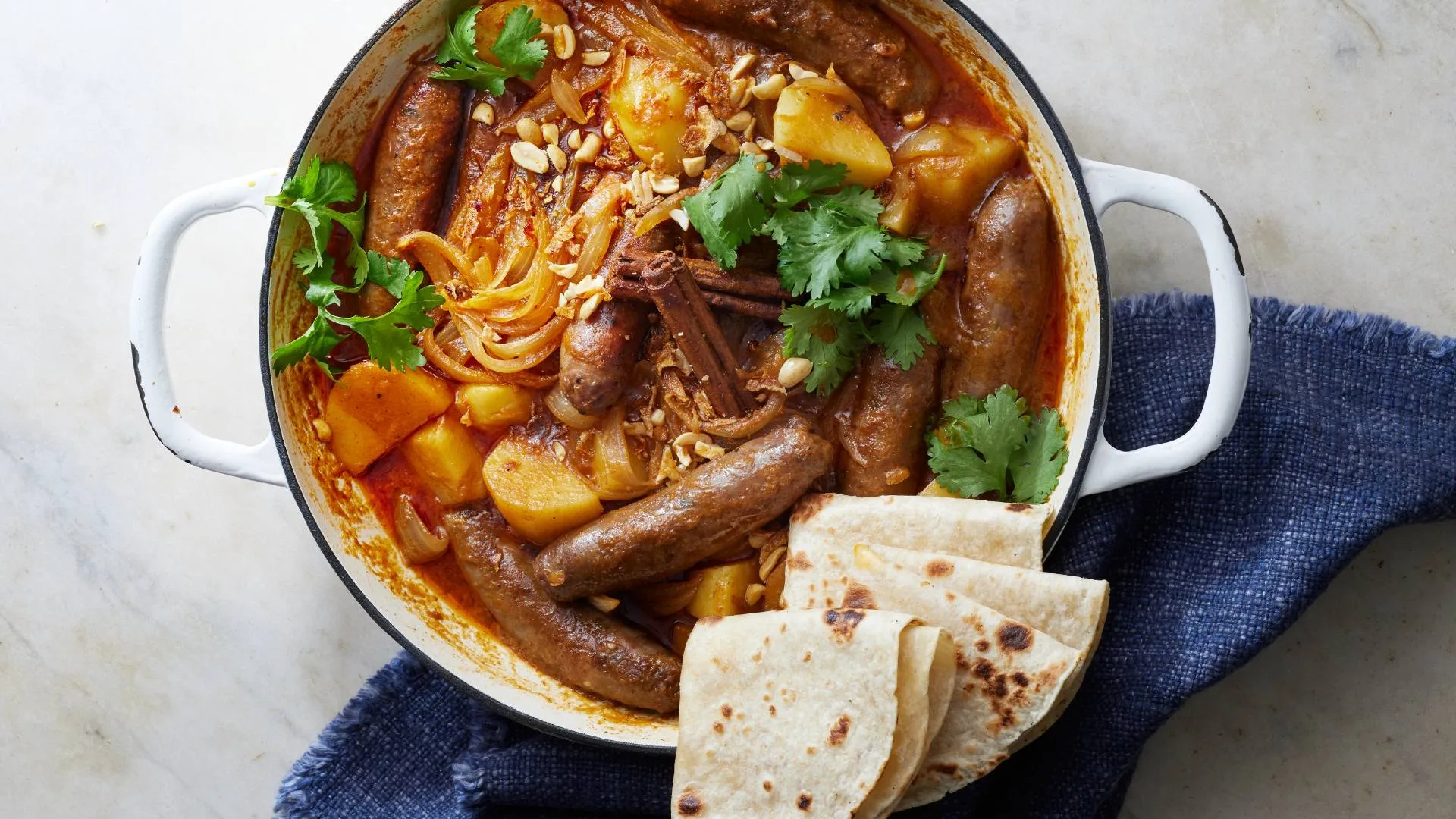 Massaman style coconut curried sausages with roti bread
