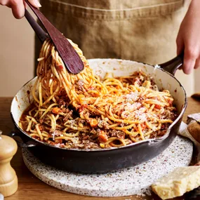 a person twirling stovetop beef ragu in a pan