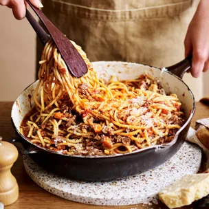 a person twirling stovetop beef ragu in a pan
