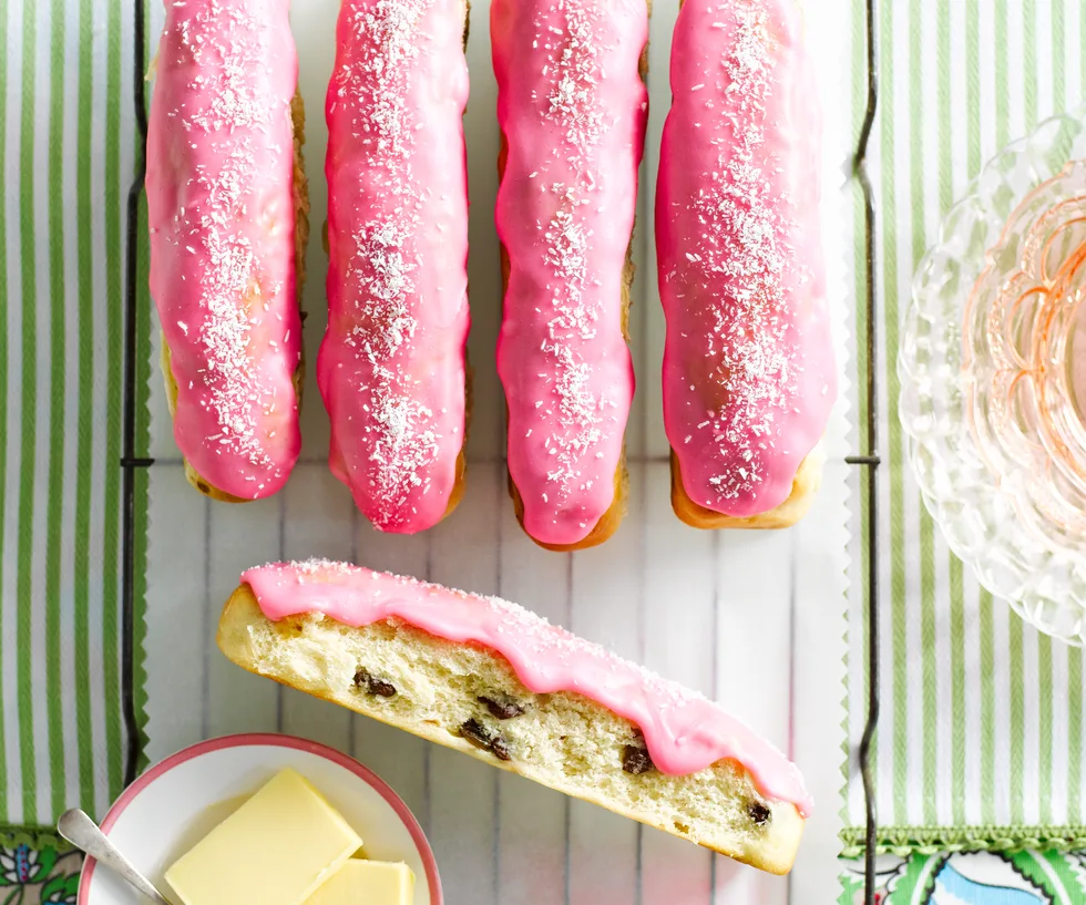 Drying rack of pink iced finger buns.