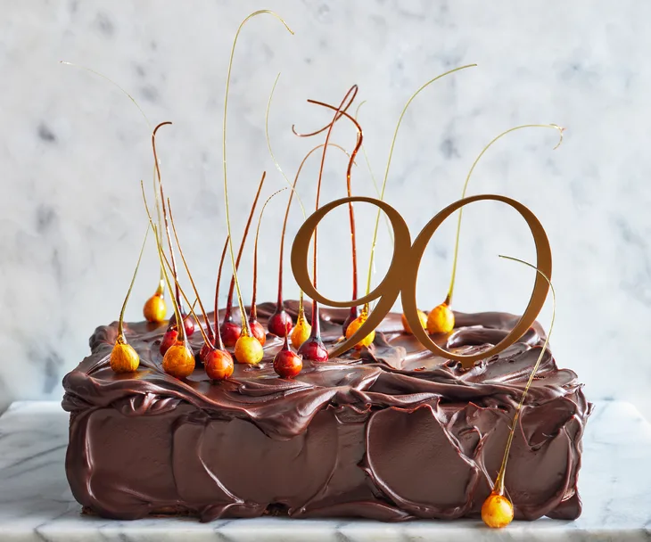 A choc-hazelnut caramel cake on a marble serving platter.