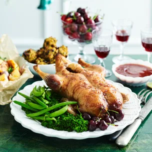 Plate of whole roast duck with mulled cranberry sauce.